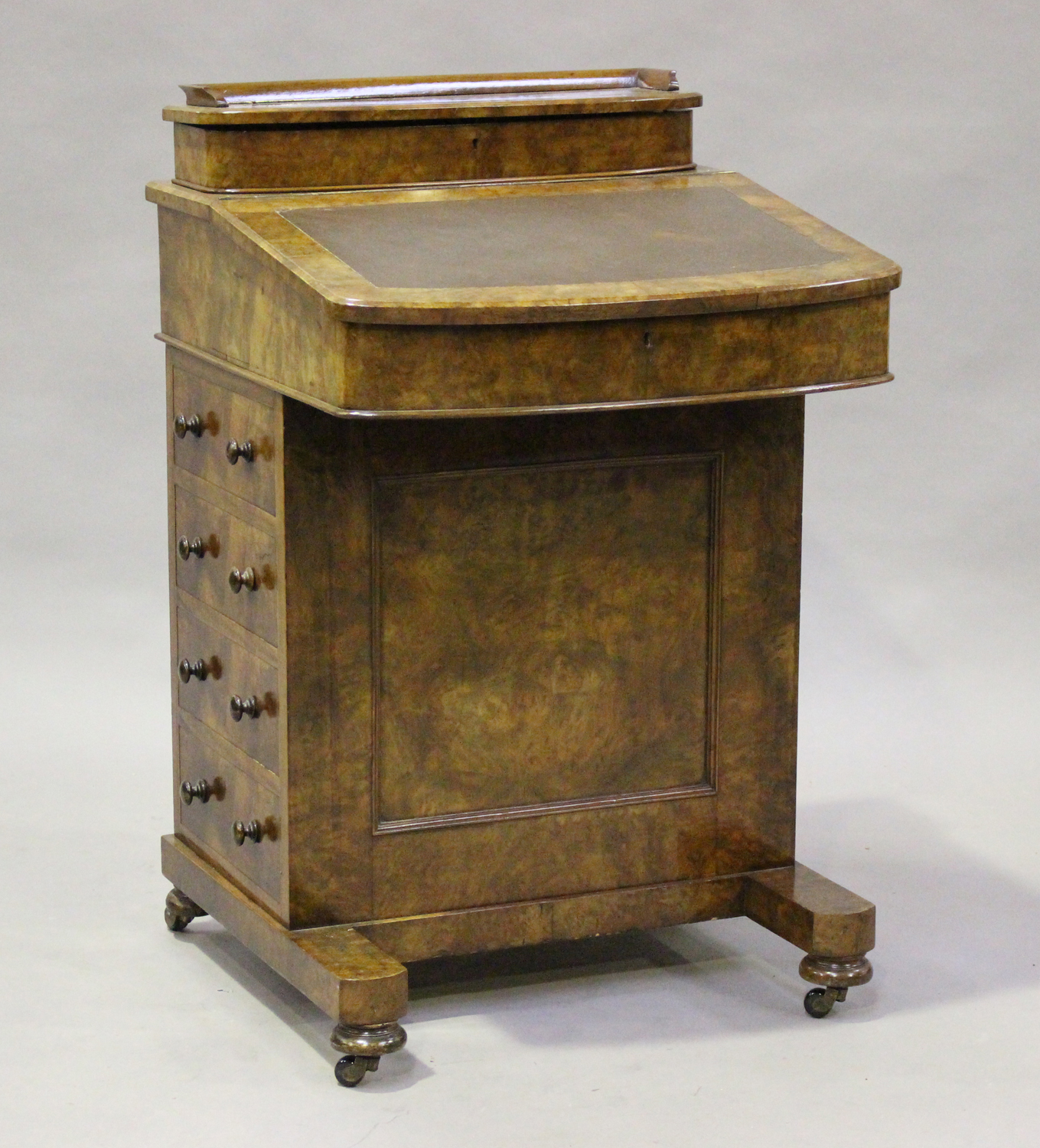 A late Victorian burr walnut Davenport, fitted with a hinged pen compartment and writing slope above