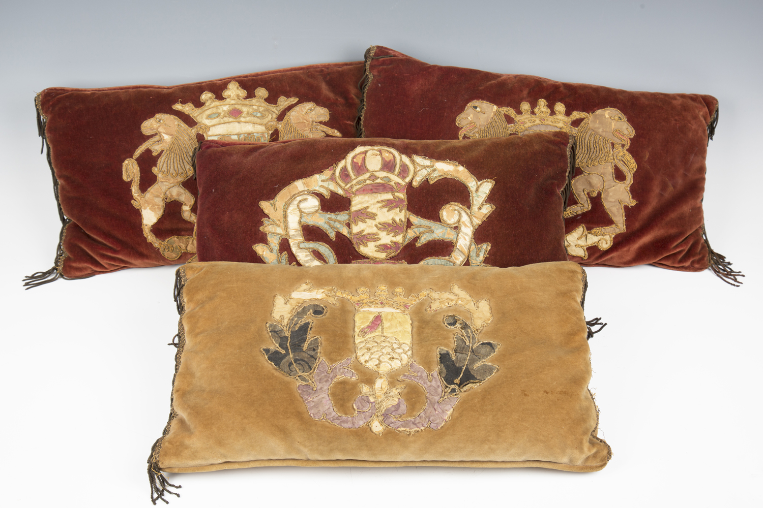 A group of four velvet cushions, purportedly made for the 1953 coronation and applied with 17th