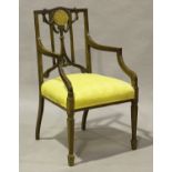 An Edwardian mahogany and boxwood line inlaid elbow chair, the carved and pierced back inlaid with a