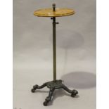 A late Victorian cast iron and oak adjustable wine table with an engraved brass stem and china