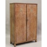 An Art Deco limed oak three-piece bedroom suite, in the manner of Heals, comprising a wardrobe,