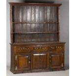 An 18th century provincial oak dresser, the shelf back above three drawers and two panelled cupboard
