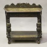 A Victorian carved oak hall table, the canted top raised on turned and baluster supports united by