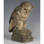 An early 20th century finely carved hardstone model of an owl perched on a rocky outcrop, inset with