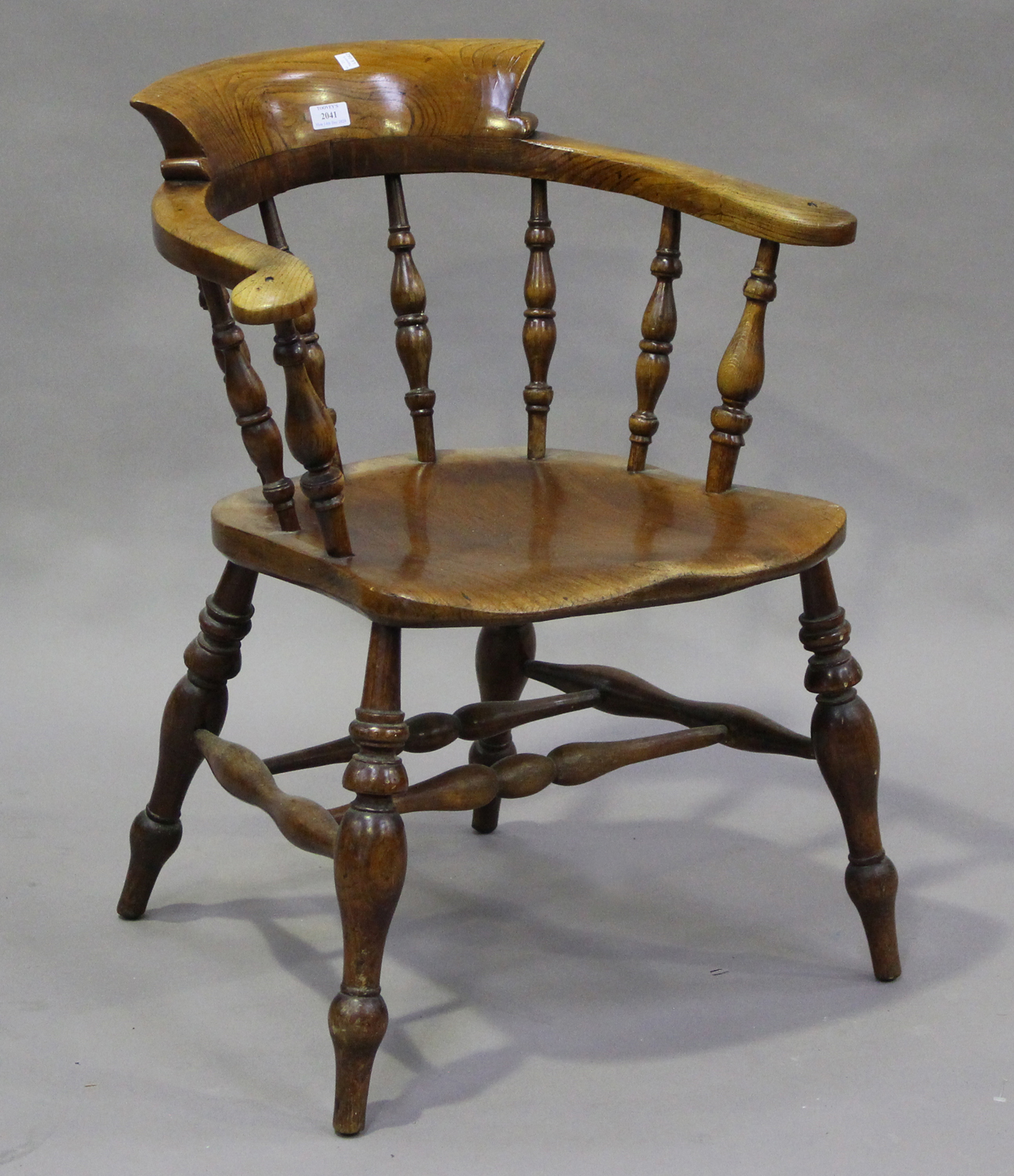 A mid-Victorian ash and elm tub back captain's chair, raised on turned legs, height 80cm, width