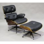 A modern black leather and walnut veneered plywood copy of an Eames lounge chair and matching
