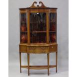 An Edwardian mahogany and satinwood crossbanded serpentine front display cabinet with overall