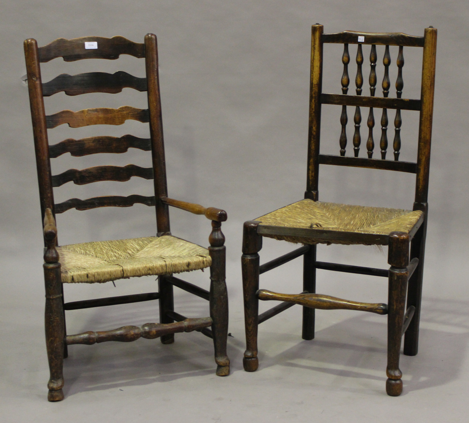 A 19th century ash and yew ladder back elbow chair with rush seat, height 97cm, width 52cm, together
