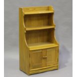 An Ercol elm waterfall open bookcase fitted with cupboards, height 111cm, width 61cm, depth 34cm.