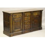 A modern 18th century style solid oak dresser base by Bylaw, fitted with drawers and panelled doors,