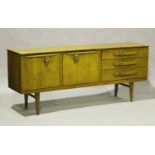 A mid-20th century teak sideboard by Beautility, the inverted front fitted with stylized belt buckle