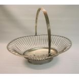 A George III large fruit basket of oval wire form with swing handle and stands on an oval pierced