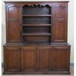 A late 18c/early 19c English oak dresser the base fitted shelves enclosed by four panel doors,