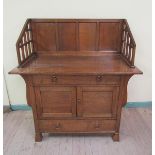 A late 19c Arts & Craft oak wash stand with a raised four panel gallery and lattice side supports,