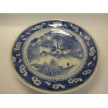 A 19c Cantonese circular dish, blue decorated with village and figures in a lakeside setting