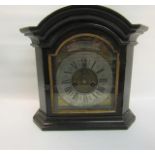 A black painted arched dial mantel clock with an arched brass dial with silvered chapter ring having