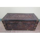 A late 19c/early 20c Oriental chamfer wood chest profusely carved in relief with figures and birds