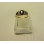 A gold sapphire and diamond ring set with central band of 3 graduated sapphires and four diamonds.