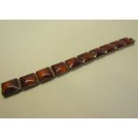 A silver square link bracelet set with amber panels