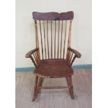 A Bodgers yew wood spindle back saddle seat rocking armchair with baluster ring turned legs and