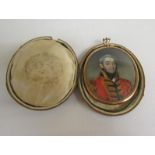 A gilt metal framed oval portrait pendant miniature of an officer in military costume and to the