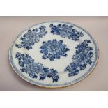 A Dutch Delft blue and white dish painted with flowers, leaves and scrolls within a geometric