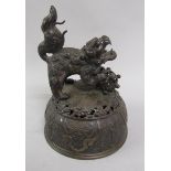 An early 19c Chinese bronze urn cover, domed and cast with panels of leaf and scrollwork and with