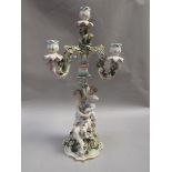 A Continental three branch candelabra with figural stem and applied flowers and leaves, slightly a/