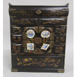 A Japanese Meiji period black lacquered table top cabinet with gilt floral decoration, having hinged