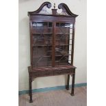 A mid Georgian style mahogany cabinet on stand, the cabinet fitted shelves enclosed by astragal