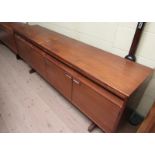 A 1970's teak sideboard fitted three frieze drawers over cupboards on shaped legs, 206cm w.