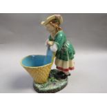 A Minton Majolica posy vase in the form of a lady grape harvester leaning on her basket, impressed