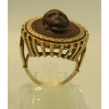 A Gents gold ring set with carved lava cameo in a circular gold mount. Ring size approx Q/R
