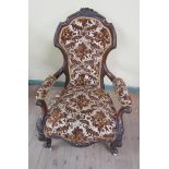 A mid Victorian carved walnut show frame and upholstered open armchair with scrolling front arm