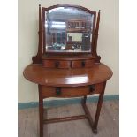 An early 20c oak Art & Craft dressing table of oval form, fitted one long frieze drawer and a