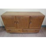 An Ercol Golden Dawn dining room cabinet of rectangular form fitted shelf and open deep cupboard