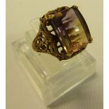 A Gold ring with set with large gemstone cut in rectangular form in a gold filigree style raised