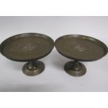 A pair of 19c bronze comports of circular dish form, supported on a single knop column with a
