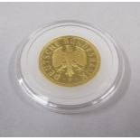 A gold one Deutsche Mark coin.