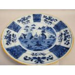A Delft dish painted in blue with a typical Oriental scene of a house, rocks and trees within a