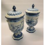 A pair of Italian Majolica vases and covers, the vases decorated with putti in lakeside settings,