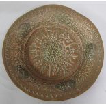 A 19c Oriental copper dish with attached brass motifs, the base decorated with a band of script