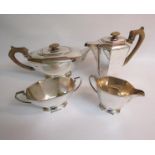 An Art Deco style four piece tea service of faceted form comprising a teapot, water jug, sucrier and