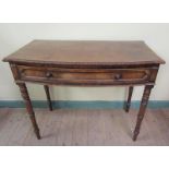 An early 19c mahogany side table of slight bow front form with carved gadroon edges, having one long