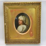 A 19c painted porcelain oval plaque depicting a lady in a white turban and gown, gilt framed, 11cm x