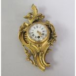 A 19c French ormolu Cartel wall clock with circular white enamel dial and Roman numerals chapter
