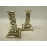 A pair of Victorian silver cased reeded column candlesticks of square stepped bases, makers mark for