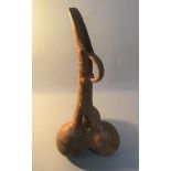 A Middle Eastern Medieval period terracotta jug of triple gourd form with long neck and pronounce