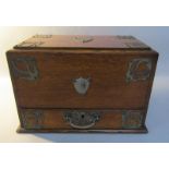 A late Victorian oak table top stationery writing box, the stationery box on a pivot operated when