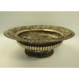 A late Georgian silver fruit bowl of circular lobed form with a raised fruiting vine cast and